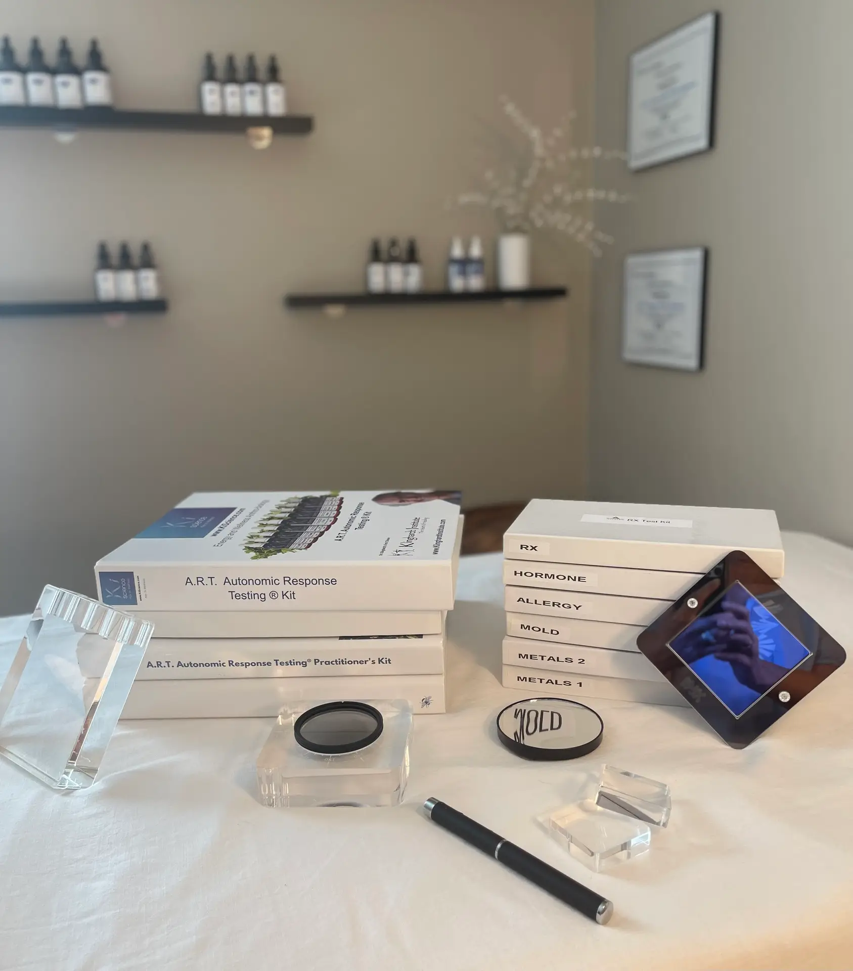 A workspace featuring Autonomic Response Testing (A.R.T.) kits, including various boxes labeled for testing different health factors, situated on a white table with decorative elements in the background.